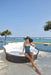 Lady with hat sitting on the edge of the Kona Daybed